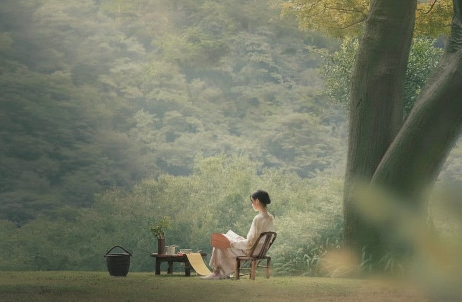 A mother resting peacefully outdoors — rest is a cornerstone of postpartum recovery